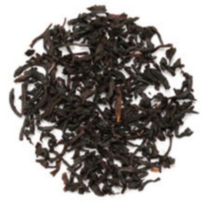 Close-up of dark black tea leaves with chocolate and caramel taste on a white background